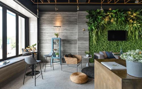 Hido Hostel في كنتيج: غرفة معيشة بجدار أخضر وكراسي