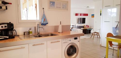 a kitchen with a sink and a washing machine at La villa marquesa in Fitou