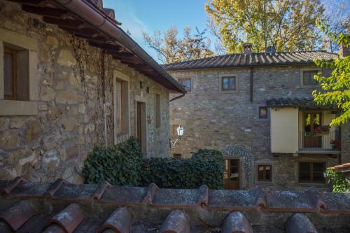 an old stone house with a fence in front of it at Fattorie di Celli in Poppi