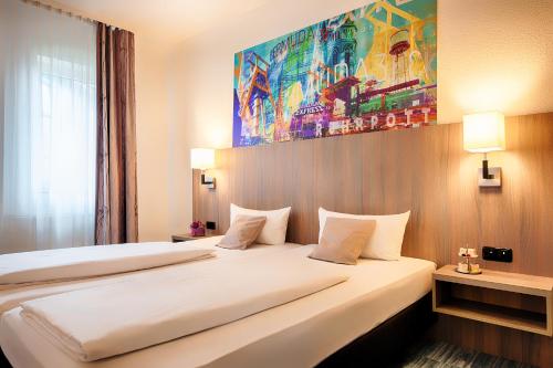 a hotel room with two beds and a painting on the wall at ACHAT Hotel Bochum Dortmund in Bochum