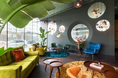 een woonkamer met een groene bank en stoelen bij Hotel2Stay in Amsterdam