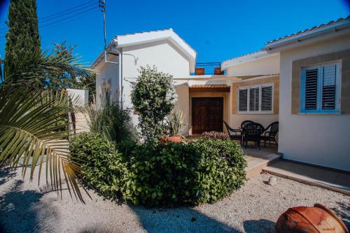 a white house with a palm tree in front of it at Beach Villa Sofia in Neo Chorio