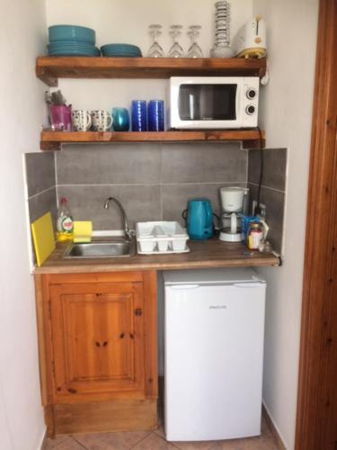 a small kitchen with a sink and a microwave at Anemos View in Firostefani