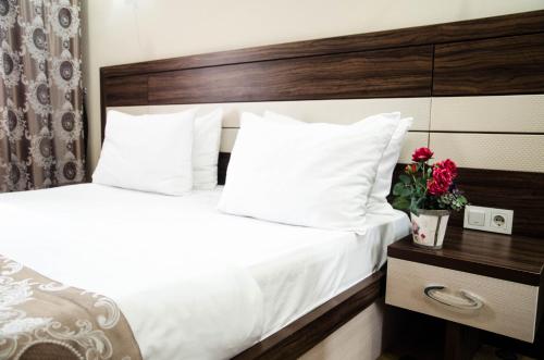 a hotel room with two beds with white pillows at Luxury House in Shymkent