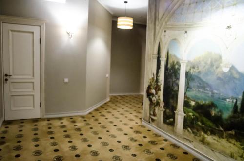 a hallway with a painting on the wall and a door at Luxury House in Shymkent