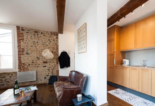 a living room with a chair and a table at Appartement Vancouver in Honfleur