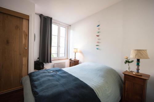 a bedroom with a bed and a window at Appartement Vancouver in Honfleur