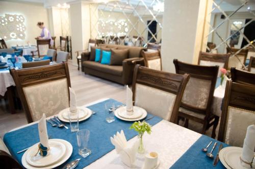 un comedor con mesas y sillas con mantel azul en Luxury House, en Shymkent