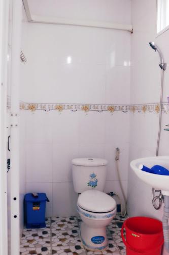 a bathroom with a toilet and a sink at Nhà Nghỉ Bảo Hân in Lai Sơn