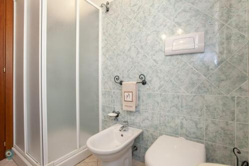 a bathroom with a shower and a toilet and a sink at Villino Bordeaux in San Teodoro
