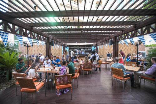 a group of people sitting at tables in a restaurant at Swissôtel Al Murooj Dubai in Dubai