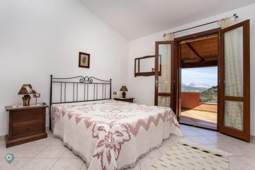 a bedroom with a bed and a door to a balcony at Villino Bordeaux in San Teodoro