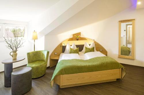 a bedroom with a large bed and a chair at Hotel Sonnenhof in Marlengo
