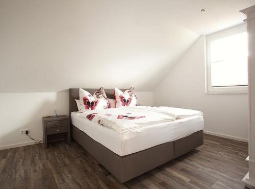 1 dormitorio con 1 cama con sábanas blancas y ventana en Ferienhaus am Rösslewald, en Breitnau