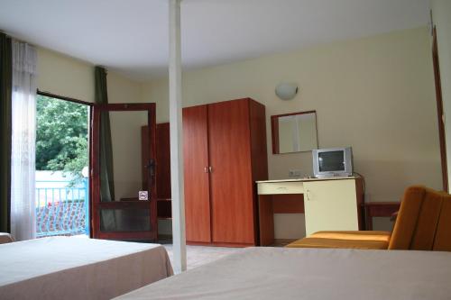 a hotel room with two beds and a tv at Oasis Villas in Golden Sands
