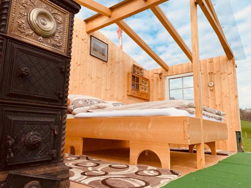 une maison en bois avec un lit dans une chambre dans l'établissement Hof Dietrich, à Herisau