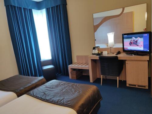 a hotel room with a bed and a desk with a computer at Best Western Hotel Tre Torri in Altavilla Vicentina