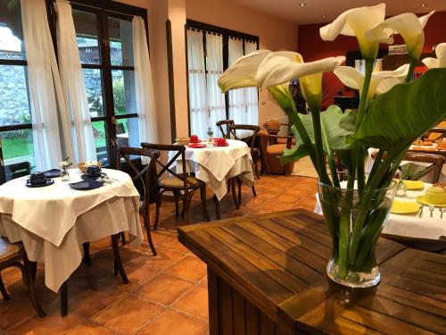 a vase of flowers on a table in a restaurant at Hotel Rural El Texeu in Llanes