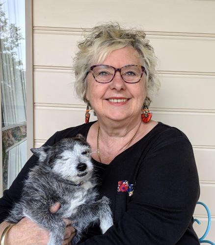 a woman with glasses holding a dog in her arms at Nicholson BnB and Arts Centre in Nicholson