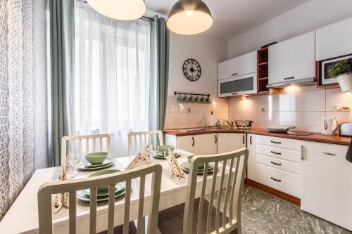 a kitchen and dining room with a table and chairs at Apartament Bulwary Zakopane in Zakopane