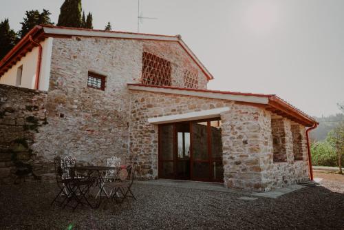 a stone building with a table and chairs in front of it at SommaVilla B&B in Vicchio