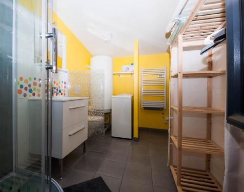 a bathroom with a shower and a yellow wall at Gîte du timbre in Clion