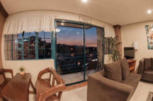 a living room with a table and chairs and a large window at The Half House by Elmar Cabin in Baguio