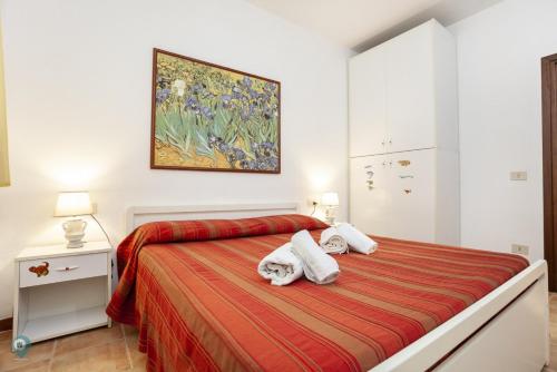 a bedroom with a bed with two towels at Villino Funtana Bilo in San Teodoro