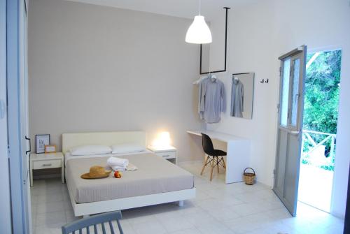 a bedroom with a bed and a desk and a chair at Galini Rooms & Apartments in Finikas