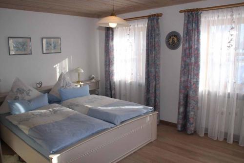 a bedroom with a bed and a window with curtains at Ferienwohnung Stoiber Wolfgang in Regen