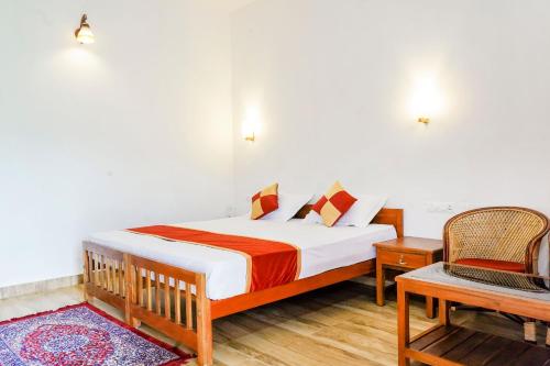 een slaapkamer met een bed met een stoel en een tafel bij Wild Mist Homestay in Munnar