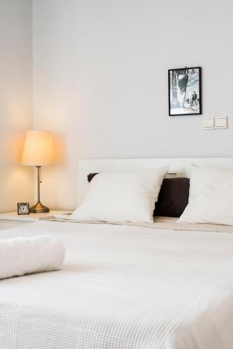 a bedroom with a white bed and a lamp at Flisvos Seafront-Marina apartment in Athens