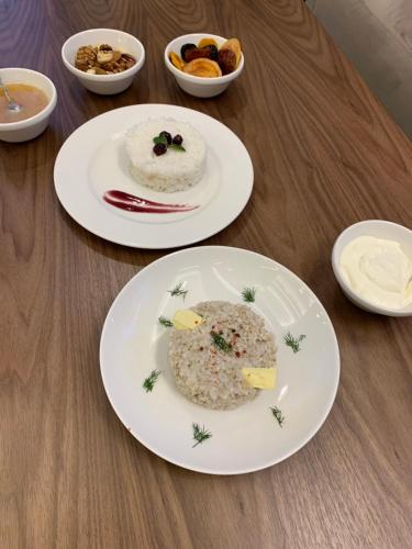two plates of food on a wooden table at Armenia in Nerkʼin Giratʼagh