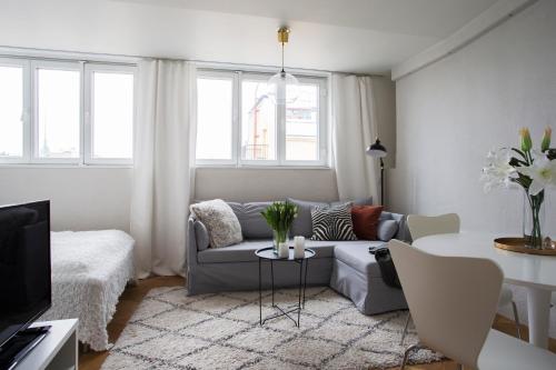 a living room with a couch and a table at 2ndhomes Ullanlinna Penthouse Apartments in Helsinki