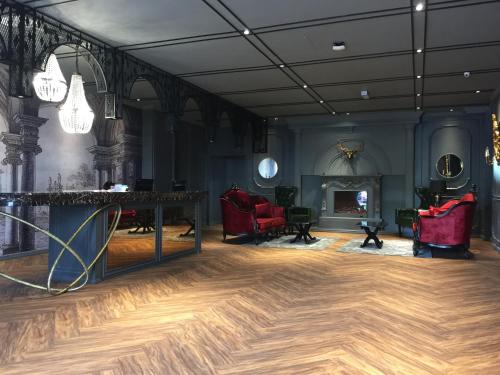 a room with wooden floors and red chairs and a fireplace at Zetter Suites @ Cameron in Cameron Highlands