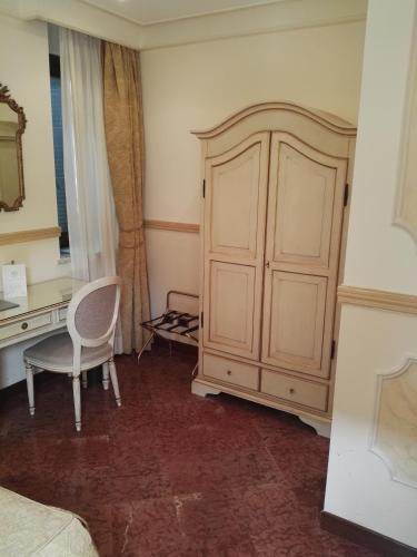 a bedroom with a desk and a cabinet and a chair at Hotel Villa San Pio in Rome