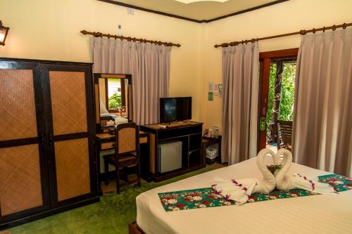 a bedroom with a bed and a television at Loyfa Natural Resort in Srithanu