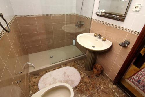 Un baño con lavabo, inodoro y ducha. en Lovely 2 bedroom house with private garden, en Mogán