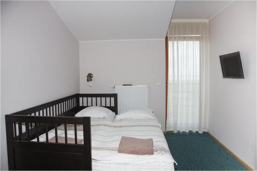 a bedroom with a bed and a television on a wall at Saulepa Seaside Villa in Saulepa