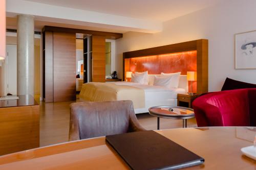 ein Hotelzimmer mit einem großen Bett und einem Tisch in der Unterkunft Aqua Aurelia Suitenhotel an den Thermen in Baden-Baden