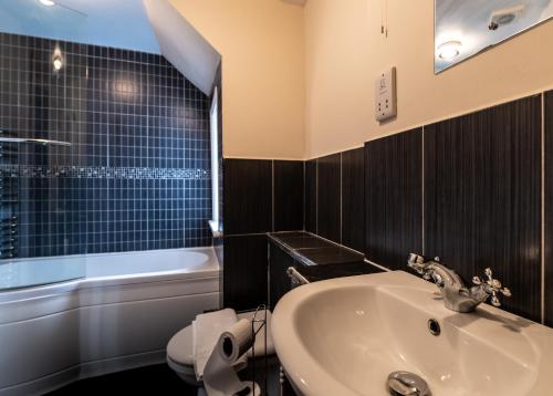 a bathroom with a sink and a tub and a toilet at The Union Inn in Cowes