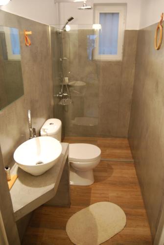a bathroom with a sink and a toilet and a shower at Galini Rooms & Apartments in Finikas