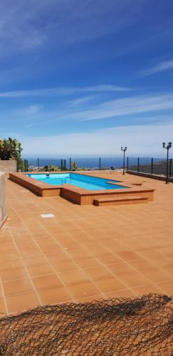 a large swimming pool with the ocean in the background at La Llave in Valsequillo
