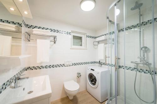 La salle de bains est pourvue d'un lavabo et d'un lave-linge. dans l'établissement Karlo's Modern Penthouse Loft, à Dubrovnik