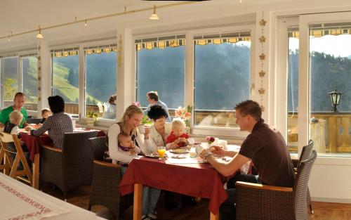 a group of people sitting at a table in a restaurant at Pension Bergbauernhof Irxner in Schladming
