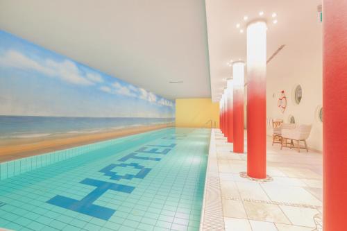 a swimming pool with a beach mural on the wall at Hotel König Ludwig in Altötting
