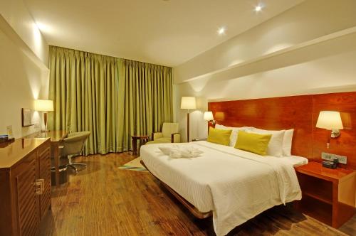 a hotel room with a large bed and a desk at Regenta Central Hestia Dahej, Bhensali in Dahej