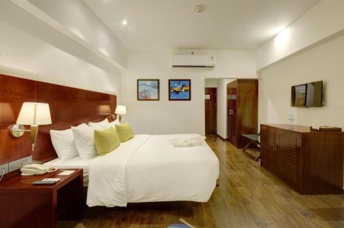 a hotel room with a large bed and a desk at Regenta Central Hestia Dahej, Bhensali in Dahej