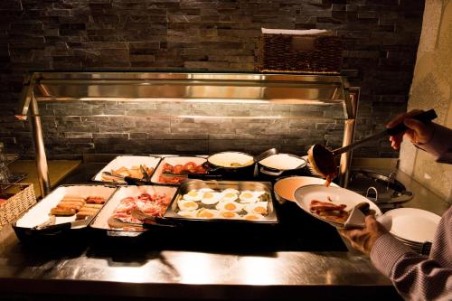 una persona che cucina su una griglia in una cucina di Patterdale Hotel a Patterdale