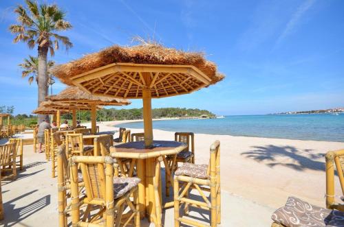 a beach with some chairs and tables and umbrellas at Apartments Karolina in Novalja